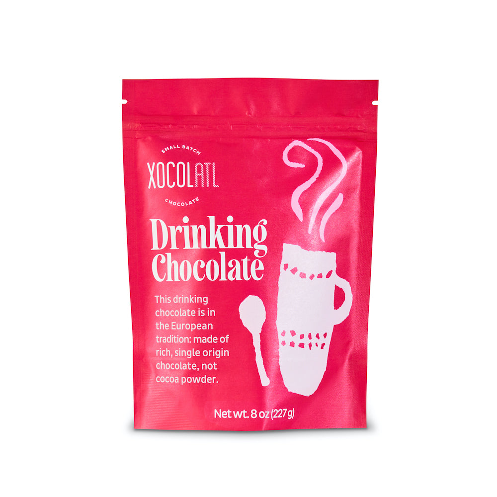 A cherry red paper pouch with the words "Drinking Chocolate", the Xocolatl logo and a whimsical mug and spoon printed on the pouch against a white background.