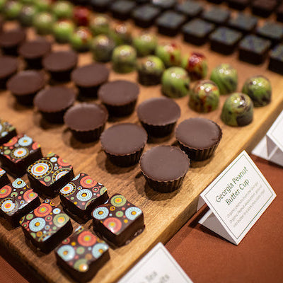 Assorted chocolates arranged in rows on a wooden board at the Flavor of Georgia contest.