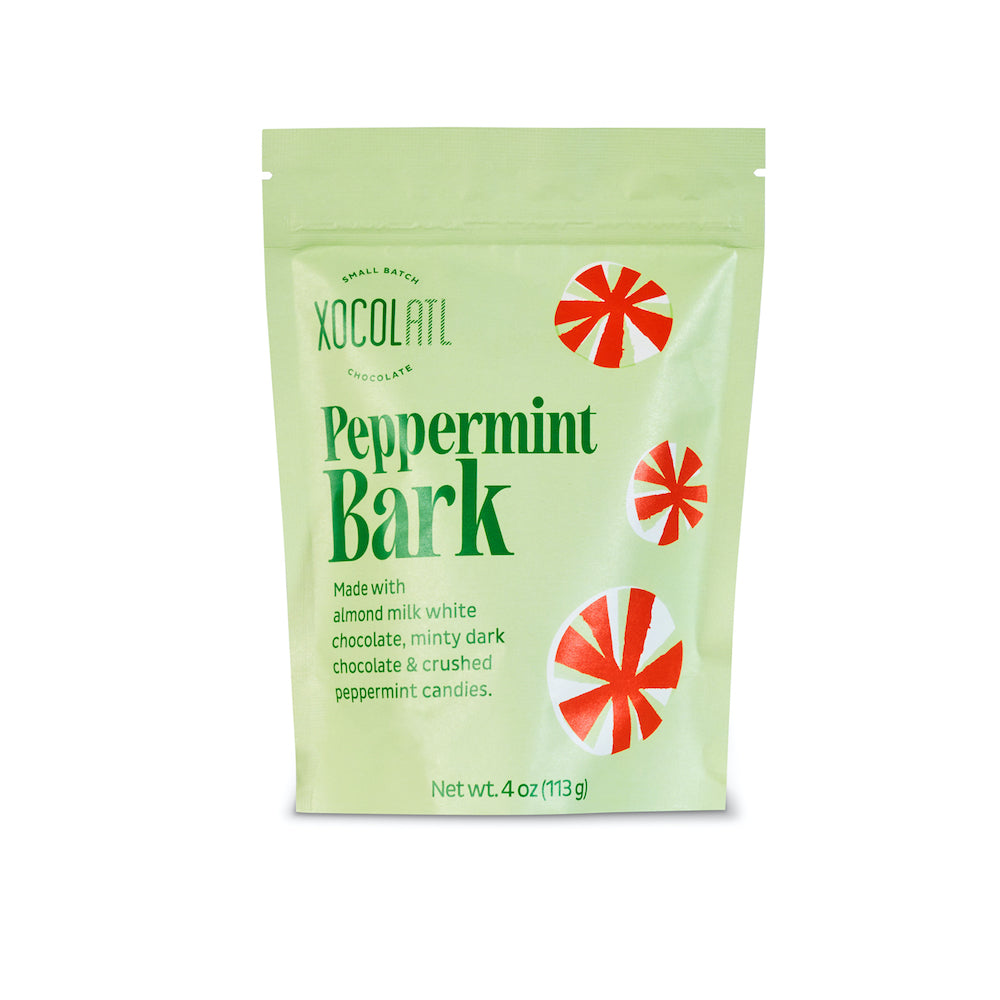 A light green paper pouch with the words "Peppermint Bark" and the Xocolatl logo, along with 3 whimsical red and white peppermint candies printed on the pouch against a white background.