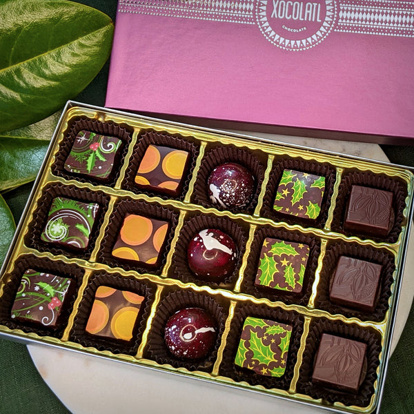Box of assorted chocolates with a purple Xocolatl box in the background